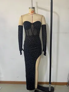 Detail of elegant black strapless evening gown with silver rhinestones and high slit