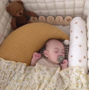 Baby nursery set with yellow moon pillow, floral blanket and cotton crib bumpers