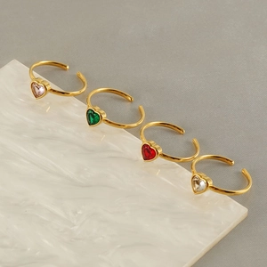 Detail of four colorful heart-shaped zircon rings in pink, green, red and clear tones