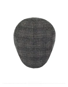 Draufsicht einer dunkelgrauen Tweed-Schiebermütze mit Karomuster und warmer Textur
