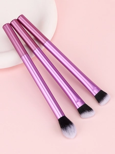 Détail de trois pinceaux de maquillage violets avec poils dégradés noirs et blancs