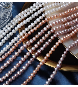 Macro detail of natural 5mm freshwater pearl strands in white and pink on blue silk