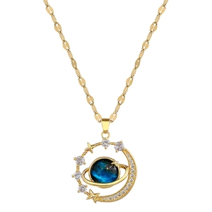 Detailed view of gold planet necklace with blue stone and sparkling zircon moon and star