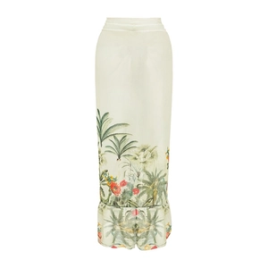 Detail of tropical palm leaf and floral prints on a sleek cream-colored one-piece swimsuit