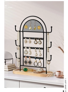 Macro view of black metal jewelry organizer featuring earring mesh and wooden base tray