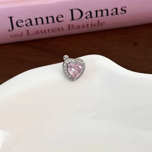 Close-up of heart-shaped pink zircon earring with silver base and micro-inlaid stones