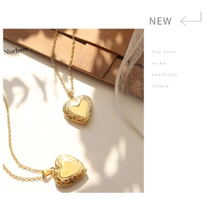 Detail of vintage 18K gold plated heart locket necklaces with engraved floral patterns