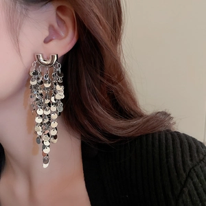 Close-up of long silver sequin tassel earrings worn by model for a trendy chic style