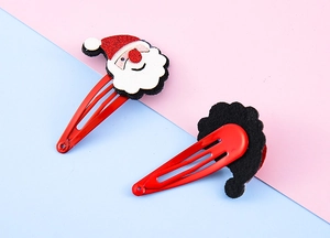 Dettaglio di fermagli per capelli di Babbo Natale con design in feltro e clip in metallo