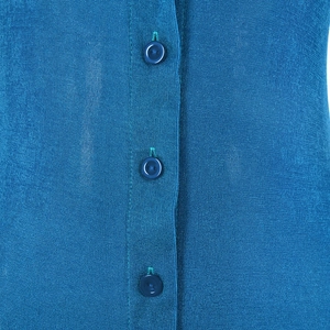Close-up of blue knit fabric texture and matching round buttons on long cardigan dress