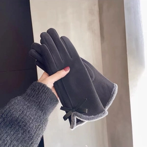 Detail of dark grey touchscreen gloves featuring plush fur lining and cute black bow accents