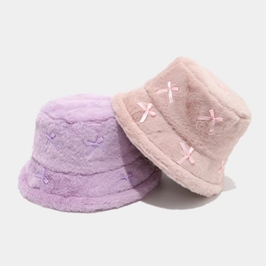 Close-up of pink and purple plush bucket hats with small silk bow details