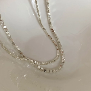 Collier minimaliste en argent avec perles carrées facettées et reflets métalliques