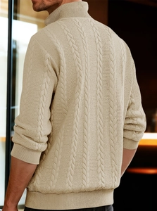 Close-up of the vintage cable-knit texture and ribbed collar on a beige chunky sweater
