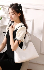 Detail of white PU leather crossbody bag with herringbone texture and front pocket design