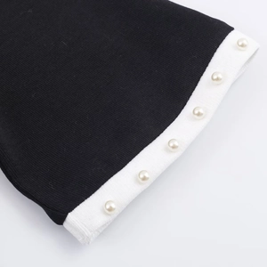 Dettaglio ravvicinato del tessuto a maglia con eleganti perle e contrasto bianco e nero