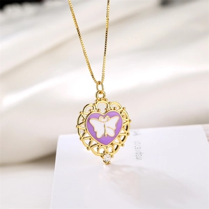 Detail of heart pendant with purple enamel, white butterfly pattern and gold filigree