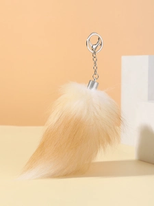 Close-up of fluffy orange and cream faux fox fur tail keychain with silver metal ring