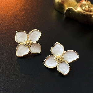 Nahaufnahme süßer Vintage-Blumenohrstecker mit perlweißen Blütenblättern und Goldrand