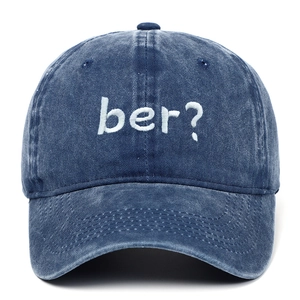 Detailed macro view of white 'ber?' embroidery on a vintage navy washed baseball cap.