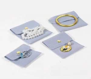 Détail de quatre pochettes à bijoux en velours bleu pour bagues, boucles et colliers