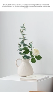 Detail view of beige matte ceramic pitcher vase with elegant white faux flowers
