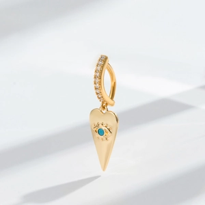 Macro shot of gold heart navel piercing with blue evil eye stone and micro-inlaid zircon