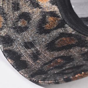Macro shot of gold foil leopard print texture and precise stitching on the hat brim