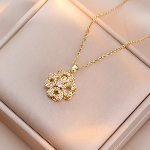 Macro view of a gold floral necklace pendant with sparkling white cubic zirconia inlay