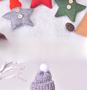 Detailed view of handmade felt star ornaments with wooden buttons and a small knitted hat