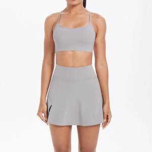 Détail de l'ensemble de yoga gris foncé avec brassière à fines bretelles et jupe plissée