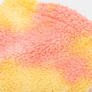 Close-up of soft tie-dye fleece fabric in yellow and pink showing plush texture