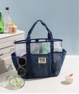 Detail of blue mesh beach bag featuring external storage pockets and BEACH LOVE patch