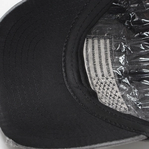 Detail of internal reinforcement, stitching, and US flag patch on washed denim baseball cap