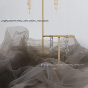 Detail of elegant silver tassel drop earrings with sparkling rhinestones on golden stand