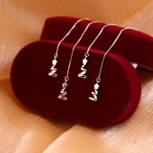 Détail de boucles d'oreilles en argent S925 avec pendentif étoile et chaîne spirale