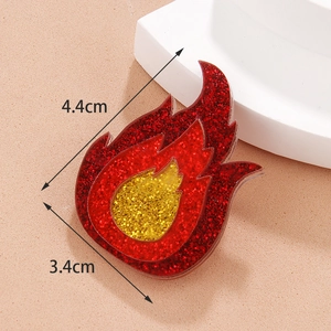 Detail view of acrylic flame brooch with red glitter finish and 4.4cm height dimensions