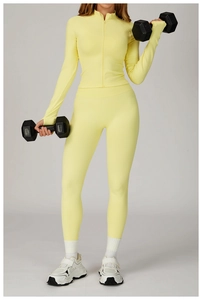 Detail of light yellow seamless ribbed yoga set with slim fit zip jacket and high waist leggings