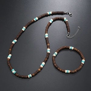 Détail de l'ensemble collier et bracelet en perles de coco sur fond noir mat