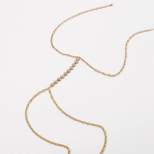 Close-up of golden body chain featuring heart-shaped sparkling rhinestone connectors