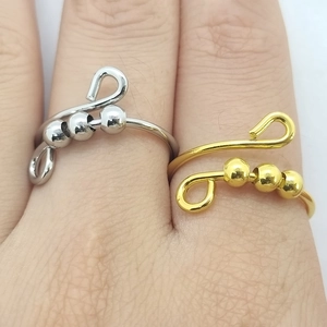 Detail of silver and gold anxiety rings with movable beads for stress relief