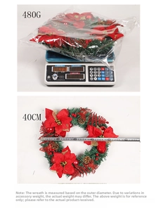 Detail view of 40cm Christmas wreath with red flowers and pine cones being weighed