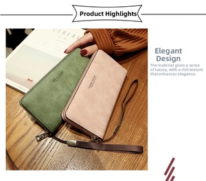 Green and pink faux leather long zip wallets with woven wristlet straps on wood