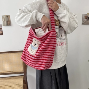 Close-up of pink striped plush shoulder bag featuring cute white bear embroidery detail