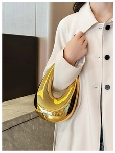 Chic gold acrylic crescent bag shown on shoulder, perfect for evening banquets and events