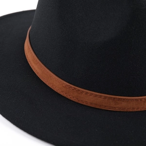 Close-up of black wool fedora hat featuring a brown leather band with fine stitching details