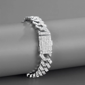 Close-up of a silver iced-out Cuban link bracelet with diamond-encrusted square clasp