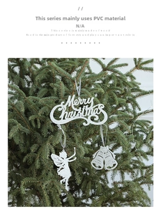 Close-up of glittery silver Merry Christmas letter set with bells on green pine tree