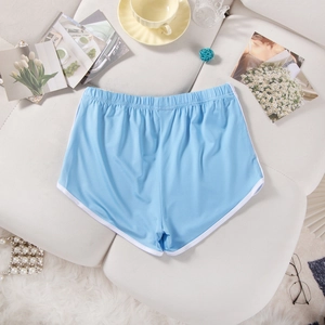 Sky blue athletic shorts with white piping on a white leather sofa with lifestyle items