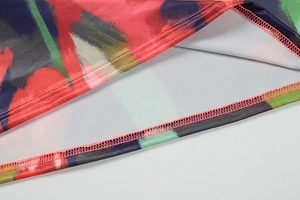 Close-up of vibrant graffiti print fabric with precise edge stitching on satin dress